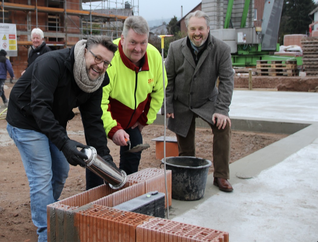 Architekt Torsten Schneider, ASB-Kreisgeschäftsführer Jens Meier und Erster Stadtrat Dr. Thomas Wolf mauern die Zeitkapsel ein.