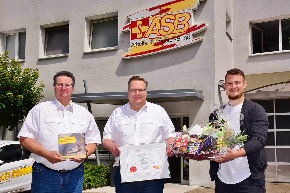 ASB-Fahrdienstleiter Uwe Köhler (li.) und ASB-Personalleiter Dominik Brede (re.) gratulieren Jörg Senne zum 25-jährigen Dienstjubiläum beim ASB