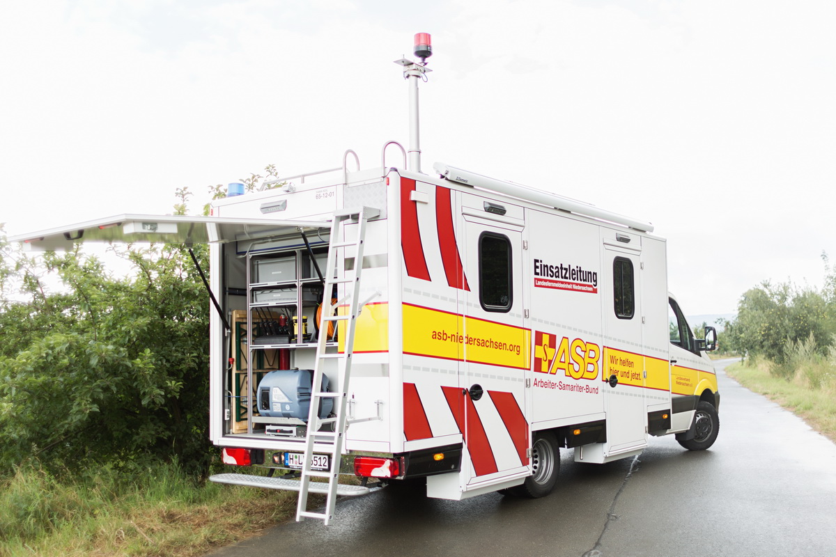 Das Team der ASB-Landesfernmeldeeinheit steht vor einem Fahrzeug,auf dem „Einsatzleitung“ steht